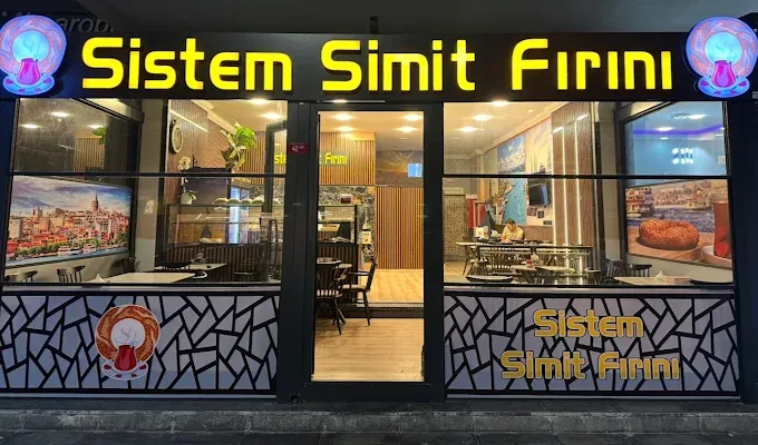 Sistem Simit Fırını’nın gece görünümü: aydınlatılmış altın sarısı tabela ve sıcak ışıklı vitrin.