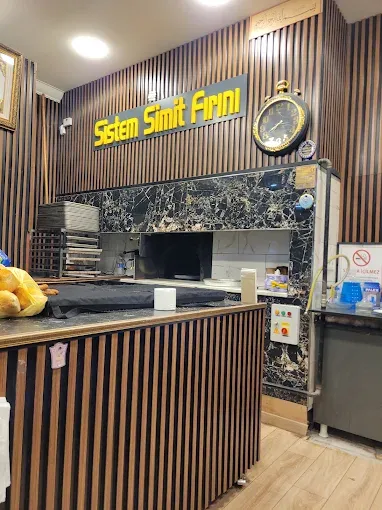 Sistem Simit Fırını’nın iç mekânı: tezgâh, taş fırın ve raflarda taze fırın ürünleri.